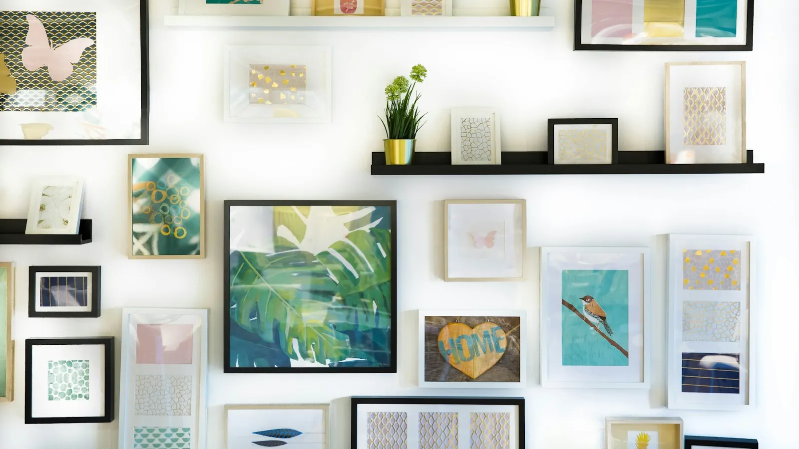 A gallery wall of framed art prints and small shelves, the way printable wall art looks once a buyer prints and hangs it